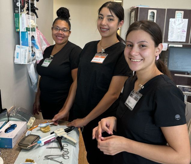 students working with dental assisting equipment in class